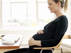Девушка беременная работает в офисе 